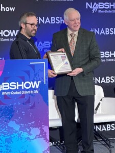 Samuel Yoffe, senior systems engineer, Neutral Wireless Ltd., receiving the 2024 NAB Best Paper Award from Lynn Claudy, senior vice president, Technology, NAB.